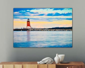 May include: A red and white lighthouse stands on a pier extending into a blue lake. The sky is a vibrant blue with fluffy white clouds. The water is calm and reflects the sky and clouds.