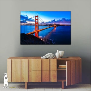 May include: A photograph of the Golden Gate Bridge in San Francisco, California. The bridge is lit up at night, with the city lights visible in the background. The sky is a deep blue with a few clouds.