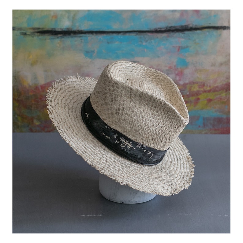 May include: A light brown straw hat with a black band and frayed edges. The band has white text that reads "Tokyo - Japan".