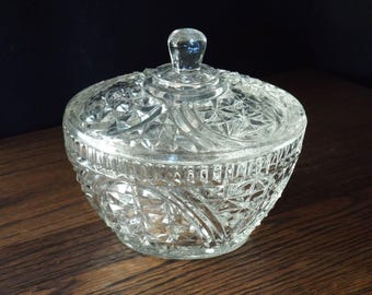 May include: A clear glass sugar bowl with a lid. The bowl and lid are decorated with a diamond pattern.