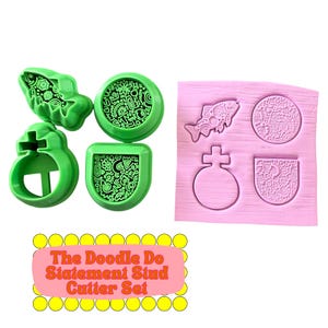 May include: A set of three green plastic clay cutters and a pink silicone mold featuring a fish, a circular shape, and a shield shape, all with intricate doodle patterns. The text "The Doodle Do Statement Stud Cutter Set" is printed below.