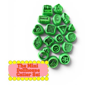 May include: A collection of green plastic mini cutters in various shapes including a heart, smiley face, peace sign, and geometric patterns. A pink rectangular label with yellow circles features the text The Mini Dollhouse Cutter Set.