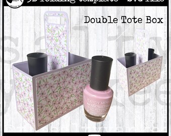 May include: A 3D folding template for a Double Tote Box, featuring a floral pattern. The box has two compartments and handles. A bottle of pink nail polish is placed next to the box. Text on the image reads "3D folding template - SVG file".