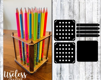 Könnte beinhalten: Holzstiftbehälter mit quadratischer Basis und vier Seiten. Der Behälter ist mit bunten Stiften gefüllt. Der Behälter hat die Worte "You lose your pencils and it's COLTS" auf den Seiten eingraviert. Der Behälter steht auf einer Holzoberfläche.
