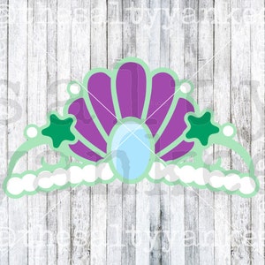 May include: A green and purple seashell crown with white pearls and green stars. The crown is made of felt and is perfect for a mermaid costume.