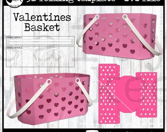May include: A pink 3D folding template for a Valentine's basket. The template includes a basket with a heart-shaped pattern and two handle options. The text "Valentines Basket" is at the top of the image. The text "no scoring tools needed" is at the bottom of the image. The text "@thesaltyyankee" is also at the bottom of the image.