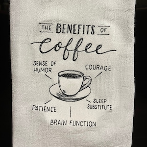 May include: White kitchen towel with black embroidery that reads "The Benefits of Coffee" with a cup of coffee in the centre and the words "Sense of Humor", "Courage", "Patience", "Sleep Substitute", and "Brain Function" around the cup.