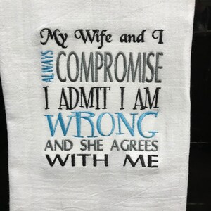 May include: White kitchen towel with blue and gray embroidery that reads "My Wife and I Always Compromise I Admit I Am Wrong And She Agrees With Me."