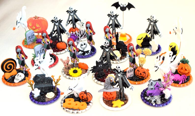 May include: A collection of 15 Halloween themed miniature figurines featuring characters from the Nightmare Before Christmas. The figurines are displayed on small round bases with various Halloween decorations, including pumpkins, ghosts, and tombstones.