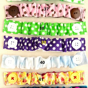 May include: Six fabric face mask extenders with different patterns and colors. The extenders have buttons on each end. The numbers 36 through 42 are printed on the extenders.