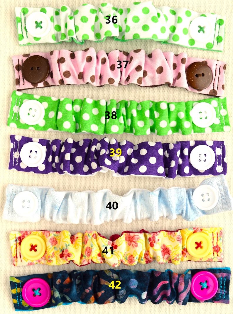 May include: Six fabric face mask extenders with different patterns and colors. The extenders have buttons on each end. The numbers 36 through 42 are printed on the extenders.
