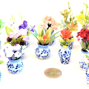 Może przedstawiać: Kolekcja 12 miniaturowych kompozycji kwiatowych w niebiesko-białych ceramicznych wazonach. Kwiaty są wykonane z plastiku i występują w różnych kolorach, w tym różowym, fioletowym, żółtym, czerwonym i białym.