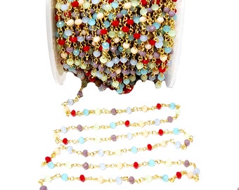 May include: A spool of gold chain with colorful faceted glass beads. The chain is made of small gold links and the beads are in shades of red, blue, green, and purple.