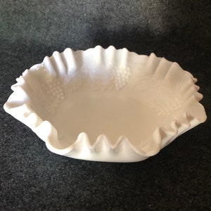 May include: A white milk glass bowl with a ruffled edge and a grape design.