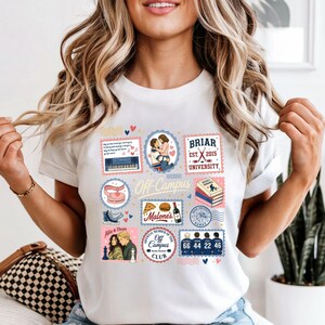 May include: White t-shirt featuring a collage of stamp-like designs with the text "Off Campus". The designs include a piano, a couple hugging, a book, a pair of ice skates, a pizza, and a chess game. The shirt also has the text "Briar University".