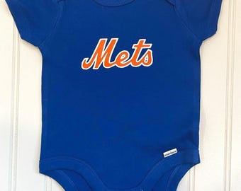May include: A blue baby onesie with the word "Mets" in orange lettering.