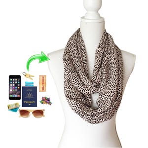 May include: A brown and black leopard print infinity scarf with a white background. The scarf is worn around the neck of a white mannequin.