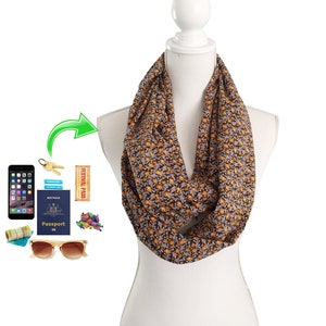 May include: A brown and orange patterned infinity scarf with a small floral print. The scarf is worn on a white mannequin.