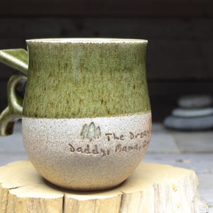 a green and white cup sitting on top of a tree stump