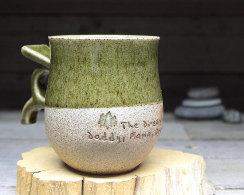 a green and white cup sitting on top of a tree stump