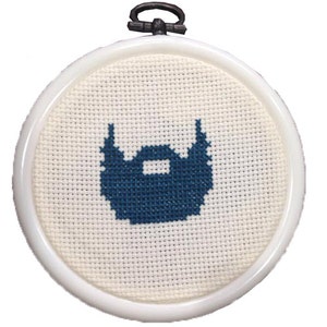 Puede incluir: Un diseño de barba azul en punto de cruz en un aro de bordado blanco.
