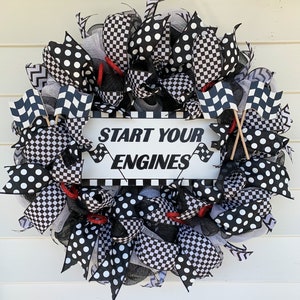 May include: Black and white checkered and polka dot wreath with a sign that reads "Start Your Engines".