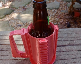 Puede incluir: Un porta botellas de cerveza rojo impreso en 3D con asa. El soporte está diseñado para mantener una botella de cerveza en posición vertical y fría.