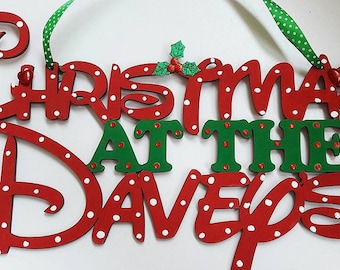 May include: Red and green Christmas sign with white polka dots that reads "Christmas at the Daveys".