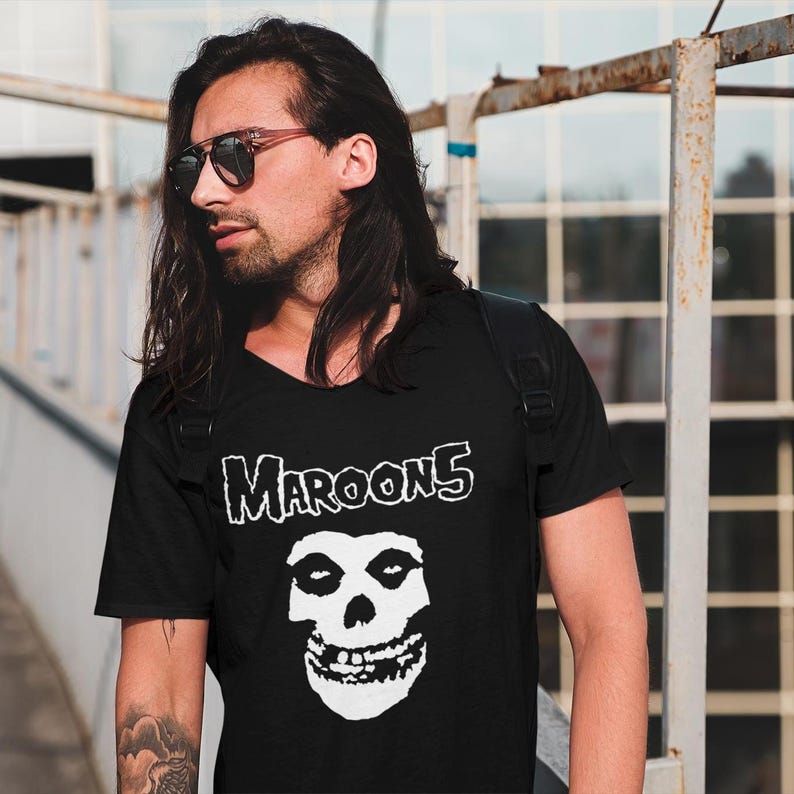 K&ouml;nnte beinhalten: Schwarzes T-Shirt mit einem wei&szlig;en Totenkopf-Motiv und dem Aufdruck "Maroon 5" auf der Vorderseite.