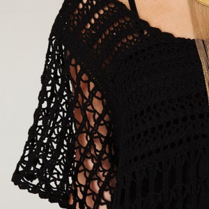 Puede incluir: Top negro de crochet con un escote amplio y abierto y un delicado patr&oacute;n de encaje. El top tiene un corte holgado y fluido y es perfecto para superponer.