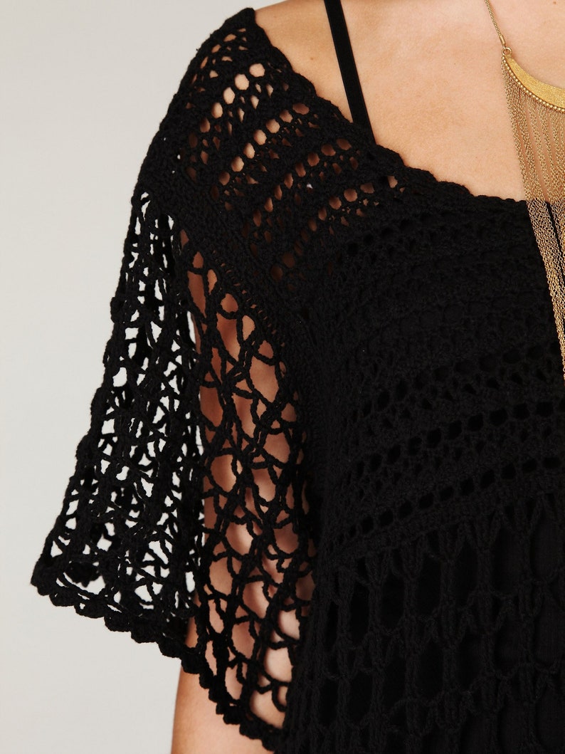 Puede incluir: Top negro de crochet con un escote amplio y abierto y un delicado patr&oacute;n de encaje. El top tiene un corte holgado y fluido y es perfecto para superponer.