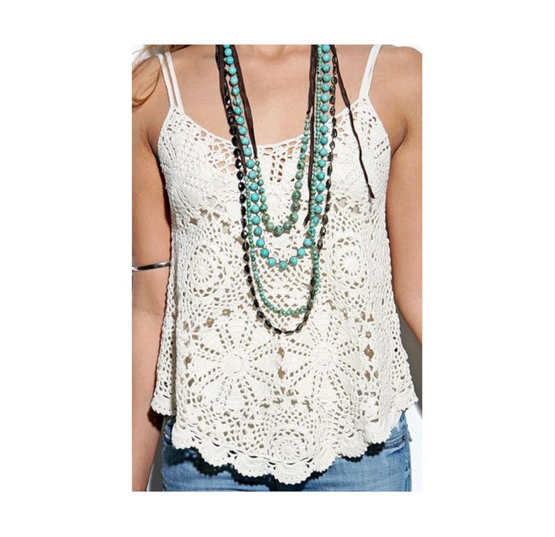 May include: A white crocheted tank top with a layered turquoise and brown beaded necklace.