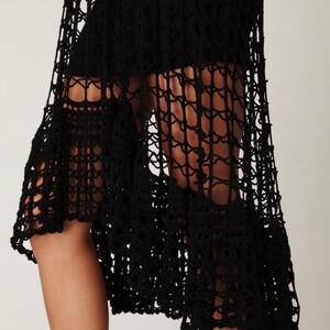 Puede incluir: Falda negra de crochet con un dobladillo de volantes superpuestos. La falda est&aacute; hecha de una tela delicada y de tejido abierto.