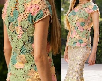 May include: A crocheted top with a floral design in shades of green, pink, and yellow. The top has short sleeves and a round neckline.