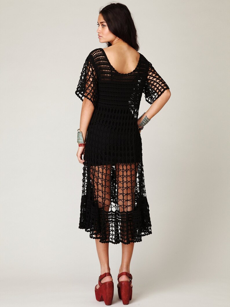 Puede incluir: Un vestido maxi de crochet negro de corte holgado y bajo festoneado. El vestido est&aacute; hecho de una tela ligera y transpirable y tiene un estilo relajado y bohemio.