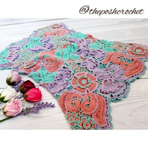 May include: A crocheted lace doily in shades of pink, purple, and green. The doily has a scalloped edge and intricate floral designs.