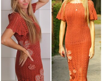 Può includere: Abito all'uncinetto color ruggine con un design floreale. L'abito ha maniche corte e una silhouette aderente, con fiori decorativi vicino alla vita e all'orlo. La trama aperta dell'uncinetto crea un aspetto strutturato.