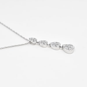 Puede incluir: Un collar de plata con un colgante que presenta cuatro racimos de peque&ntilde;as piedras de circonita c&uacute;bica transparentes en forma de l&aacute;grima.