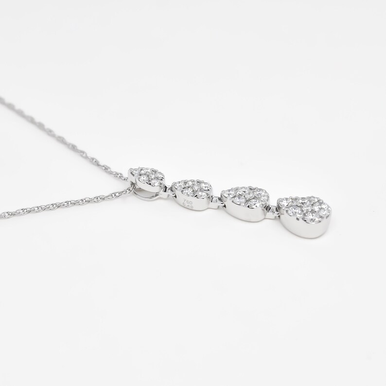 Puede incluir: Un collar de plata con un colgante que presenta cuatro racimos de peque&ntilde;as piedras de circonita c&uacute;bica transparentes en forma de l&aacute;grima.