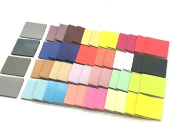 May include: A collection of 30 small, square, fabric swatches in various colors, including gray, blue, brown, pink, green, yellow, and black. The swatches are arranged in rows, with the darkest colors at the top and the lightest colors at the bottom.