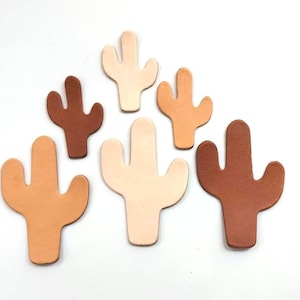 May include: Five leather cactus shapes in various sizes and shades of brown and beige.
