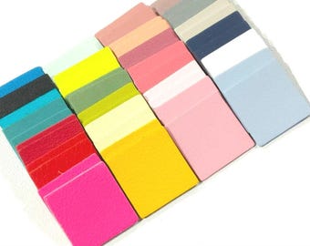 May include: A collection of 20 small, square leather samples in various colors, including black, blue, green, red, yellow, pink, and white.