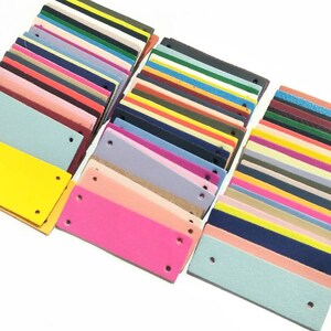 May include: Assortment of colorful leather patches with two holes each. The patches are arranged in rows and columns, showcasing a variety of colors and textures.