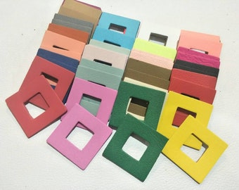 May include: Assortment of colorful leather squares with a square cutout in the center. The squares are arranged in rows and columns, with each square a different color.