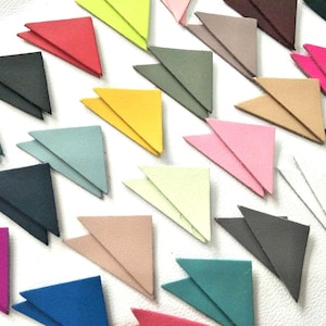 May include: Assortment of 18 double-layered leather triangle shapes in various colors, including pink, blue, green, yellow, and black.