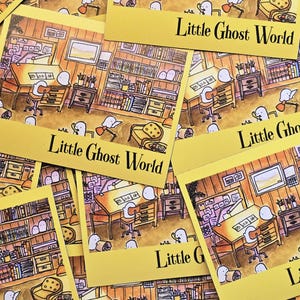 May include: A collection of yellow cards featuring an illustration of a room with furniture, bookshelves, and cartoon ghosts. The text "Little Ghost World" is printed in black on each card. The cards are scattered across a surface.
