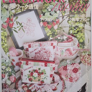 May include: A magazine cover featuring strawberry-themed patchwork crafts. The cover includes a framed embroidery, pouches, and a teacup, all decorated with strawberry motifs. The magazine title is in pink, with Japanese text.