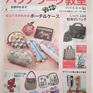 May include: A magazine cover featuring various handmade fabric items, including pouches, bags, and cases. The cover has Japanese text and showcases different patchwork projects with colorful designs and patterns. The magazine is titled "Patchwork Classroom".