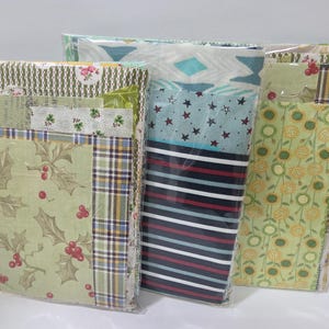 May include: Three clear plastic packages containing assorted fabric squares. The collection features various patterns including green holly leaves with red berries, plaid, blue stripes, red stars, and yellow floral designs on light green backgrounds.