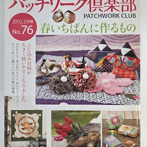 May include: A Japanese craft magazine cover, "Patchwork Club," displays handmade items. The magazine title is in Japanese and English. The cover showcases fabric flowers, dolls, and a quilt, with text indicating the March 2010 issue. The magazine is about patchwork.